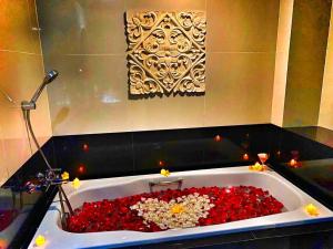 a bath tub filled with lots of red flowers at Balairung Hotel Jakarta in Jakarta