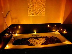 a bath tub with candles and rocks in it at Balairung Hotel Jakarta in Jakarta
