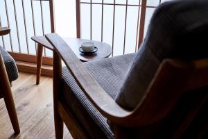 a wooden chair with a cup on a table at Kikokutei Bekkan in Kyoto