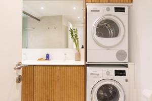 a bathroom with a washing machine and a washer and dryer at Scalinada Luxury Suites in Corfu Town