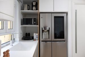 a kitchen with a refrigerator and a microwave at Scalinada Luxury Suites in Corfu
