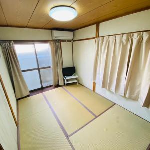an empty room with a chair and a window at Guesthouse Kumano in Tanabe