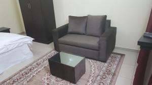 a living room with a chair and a table at العييري للشقق المفروشة حائل1 in Hail