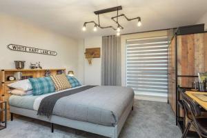 ロンドンにあるNewly Built Luxury 2 Bed Apartment!!!のベッドと机と窓のある寝室