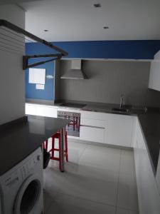 a kitchen with a sink and a washing machine at Designer Studio Camps Bay in Cape Town