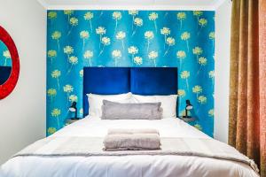 a bedroom with a blue wall with yellow dandelions at Green Park Haven 1 in Pretoria