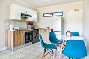 a kitchen with a table and blue chairs at Green Park Haven 1 in Pretoria