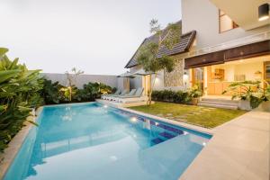 a swimming pool in the backyard of a house at Vasudha Hostel Canggu in Canggu