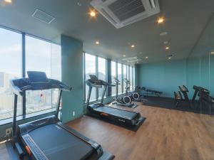 a gym with treadmills and ellipticals in a room with windows at Susukino Granbell Hotel in Sapporo +97 photos