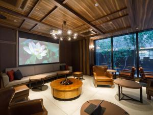 a living room with a couch and a large screen at Susukino Granbell Hotel in Sapporo