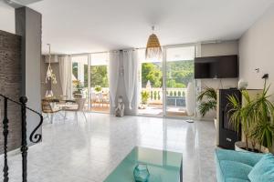 a living room with a blue couch and a glass table at Villa Felicidad in Font de Sa Cala