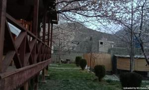 a yard with a fence and a mountain in the background at Northern Sapphire in Hunza
