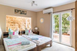 a bedroom with two beds and a sliding glass door at Villa Felicidad in Font de Sa Cala +20 photos