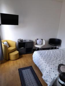una camera con letto, divano e sedia di Le Samwest ad Arromanches-les-Bains