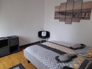 a bedroom with a bed and a desk with a clock on the wall at Le Samwest in Arromanches-les-Bains