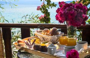a table with a tray of bread and orange juice at Poseidon Apartments in Tolo