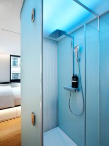 a glass shower in a room with a bed at citizenM Paris Champs-Élysées in Paris