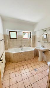 a large bathroom with a tub and a sink at Pensiunea Kalinder in Buşteni