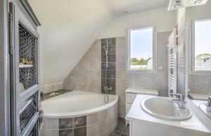 a bathroom with a tub and a sink at Maison vue mer dans le Golfe du Morbihan in Baden +50 photos