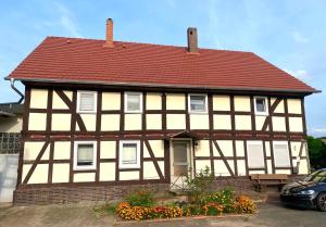 a yellow and white house with a red roof at PferdeFairStand‘s Ferienwohnung in Haunetal