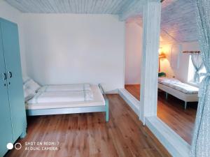 a small room with a bed in a room with wooden floors at Ubytování Na statku in Stará Červená Voda