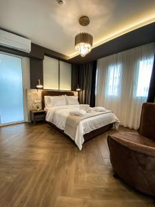 um quarto com uma cama grande e um lustre em FILEO ELEGANT LIVING em Veria