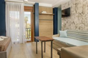 ein Wohnzimmer mit einem Sofa und einem Tisch in der Unterkunft 3D iliadis Suites in Ierissós