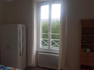 a kitchen with a refrigerator and a window at La coulée pilette in Callac +18 photos