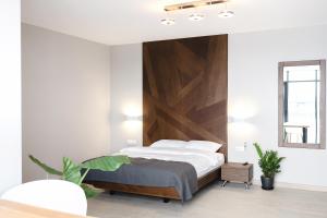 Schlafzimmer mit einem Bett mit einem Kopfteil aus Holz in der Unterkunft Sofia Hotel in Velyka Omelyana