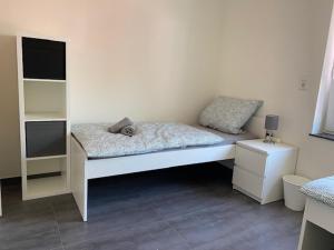 Una cama blanca en una habitación con en 3 Mehrbettzimmer, Küche, Bad für Arbeiter und Monteure, en Gau-Weinheim