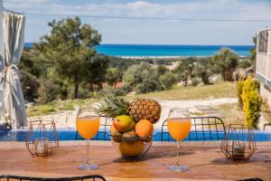 a table with a bowl of fruit and glasses of orange juice at Villa Patara Flower in Patara