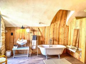 a bathroom with a tub and a sink at Les Volets Rouges in Arbois