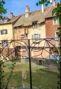 une clôture en fer devant un bâtiment dans l'établissement Les Volets Rouges, à Arbois