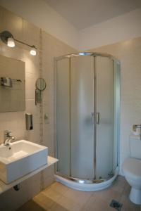 een badkamer met een douche, een wastafel en een toilet bij Indigo Studios in Livadion