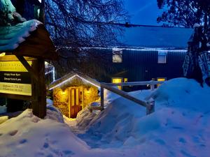 a house covered in snow at night with lights at Feathertop Alpine Lodge in Falls Creek