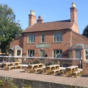 a building with wooden benches in front of it at The Riverside Rooms in Newark-on-Trent