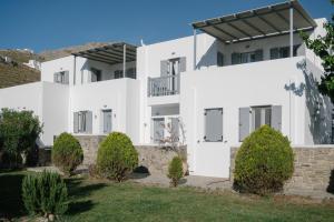 a white house with trees in front of it at Indigo Studios in Livadi