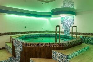 a jacuzzi tub in a room with blue tiles at Prince Vladimir in Vladimir
