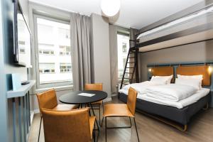 a bedroom with a bed and a table and chairs at Comfort Hotel Børsparken in Oslo