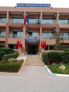ein Hotel mit Flaggen vor einem Gebäude in der Unterkunft Hotel Residence Imiplage in Agadir