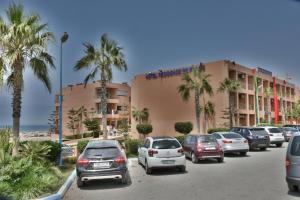 um parque de estacionamento com carros estacionados em frente a um hotel em Hotel Residence Imiplage em Agadir