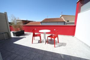 two red chairs and a table on a patio at IsolaDino b&b sweet home in Praia a Mare