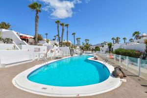 a pool at the resort with palm trees at Puerto Chico 2 in Playa Blanca
