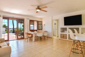 a living room with a tv and a table and chairs at Puerto Chico 2 in Playa Blanca