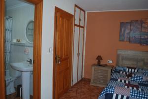 a bathroom with a bedroom with a bed and a sink at Apartamento Rural Lago Ercina in Cangas de Onís