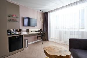 a living room with a couch and a table and a tv at Ugor Hotel in Syktyvkar