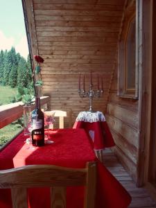 a table with a bottle of wine on a red table cloth at Willa Arnika in Lutowiska