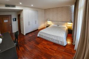 um quarto com uma cama grande e piso em madeira em La Bohème Hotel em Tirana
