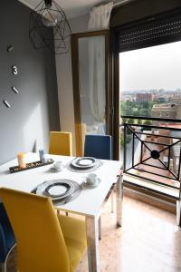 a dining room with a white table and yellow chairs at El Torreón del Pilar. Opción de parking in Zaragoza