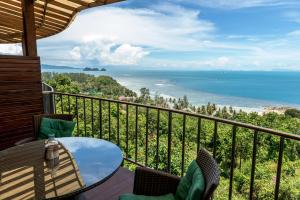 balcón con mesa, sillas y vistas al océano en Sunset Hill Boutique Resort Koh Phangan en Haad Chao Phao